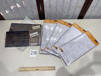 Group shot of six sealed adapter plates on table with ruler for scale