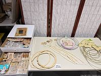 Overview of all supplies on table: bead strands, wreath frames, packed embellishments