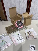 All components laid out including die cutter, grid mat, cartridge, manuals, boxes