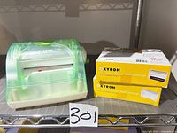 Machine and two boxed cartridges on shelf