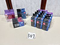 Group of boxed sticker makers and multiple refill cartridges on table