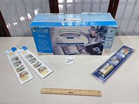 Boxed YourStory laminator with accessory foil and glue strip packs plus ruler for scale