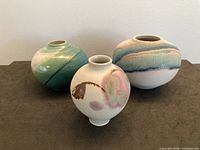 three small banded-glaze stoneware vases front and back