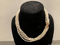 Front view of five-strand pearl necklace displayed on bust