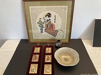 Group view of framed textile art, two velvet print panels, ceramic bowl and vase