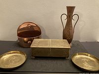 Group shot of copper pot, brass box, copper vase, two brass trays