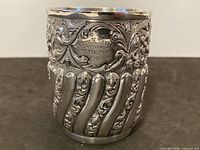 Front view showing repousse design, cartouche inscription and fluted lower body