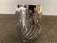 Front view showing engraved crest and date on sterling mug