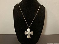 Cross pendant on chain displayed on bust
