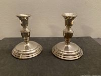 Front view of both Birks sterling silver weighted candlesticks