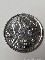 Reverse of coin showing hockey player, sport inscription, maple leaf, Olympic rings