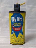 Front view of Ronson Oily Bird lubricant tin showing graphics and spout