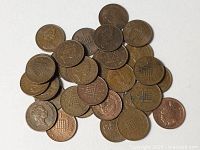 Pile of approximately 30 UK one-penny coins showing mixed patina.