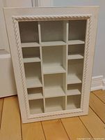Front view of closed curio cabinet showing rope-moulded glass door and cubby layout