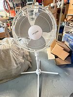 Front view of white Likewise pedestal fan showing blades, grille, stand and base