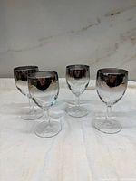Four silver fade stemmed wine glasses front view