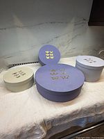 Five round Bon Matin Collection boxes with gold butterflies