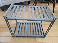 Rack fully assembled showing two slatted grey shelves and side frames