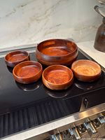 complete set of one large and four small wooden bowls displayed
