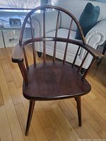 Front view of wooden armchair showing hoop back, spindles, arms and seat