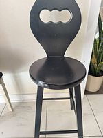 Front view of black wooden bar stool