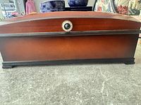 Front view of closed Bombay cherry wood jewelry box showing domed lid, knob, color and base trim