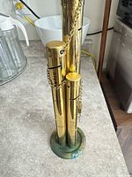 Full view of brass tube coin bank on countertop