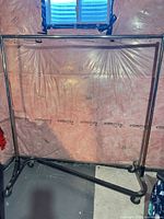 Full view of chrome garment rack showing casters and Z-base