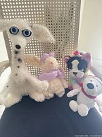All four plush toys seated together on chair