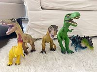 All six dinosaur figures lined up on rug
