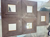 Front view of five dark brown square mirrors with glass centers