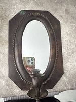 Front view showing octagonal frame, oval mirror, candle cup