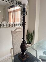 Full view of bronze metal table lamp on glass table