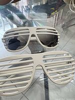 Front view of both shutter sunglasses on glass table