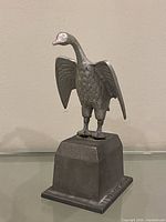 Front view of cast metal eagle on pedestal