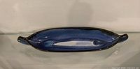 Top view of elongated blue glazed ceramic dish with integral handles