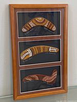Full view of framed boomerang collection showing three painted boomerangs