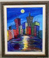 Full view of framed painting with cityscape and signature visible