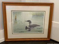 Front view of framed lithograph showing loon scene, matting, and wooden frame