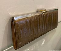 Full side view of clutch showing glitter finish and chrome frame