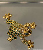 Front view of Monet gold-tone frog brooch showing rhinestone detailing