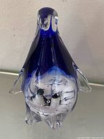 Front view of cobalt blue glass penguin showing internal baby penguins