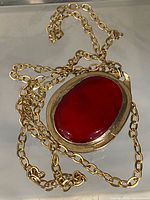 Front view showing red cabochon pendant and chain