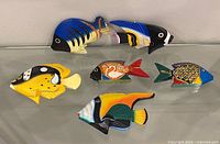 All six hand-painted wooden fish on glass shelf