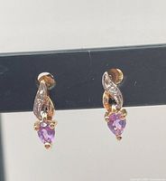 Front view of both earrings showing gold setting and purple stones