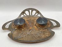 Front view showing overall design, two lidded inkwells, Art Nouveau motif
