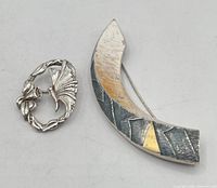 Front view of both brooches showing designs and finishes