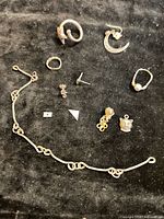 Overview of all eleven sterling silver items on black background