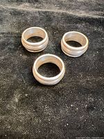 Three sterling silver spinner rings on dark cloth