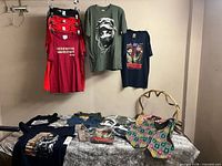 Overall lot showing hanging and folded Che Guevara T-shirts with basket, belt and earrings